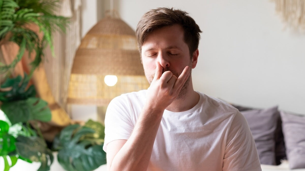 un homme pratiquant le yoga assis, faisant une respiration nasale alternée