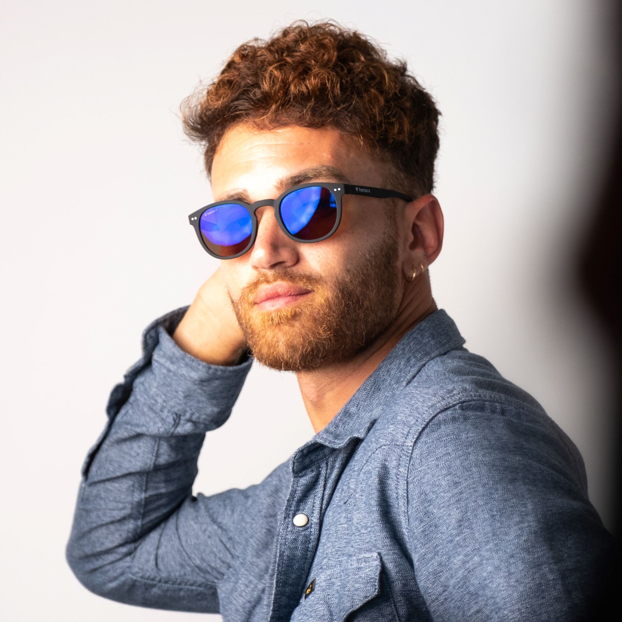 Lucas porte nos lunettes de soleil anti lumière bleue de face, sur fond gris