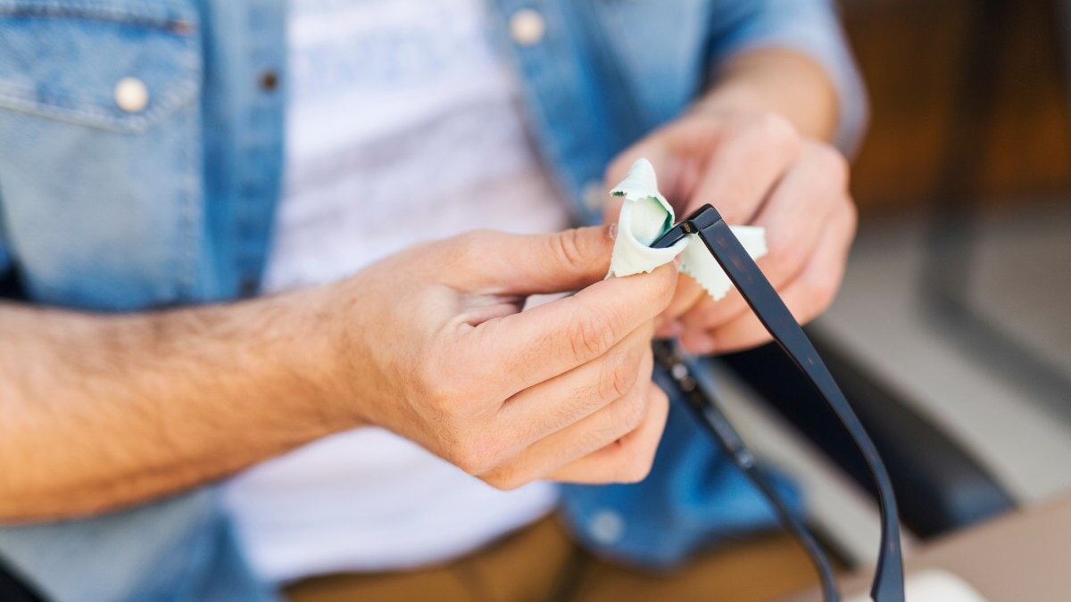 un homme nettoyant ses lunettes