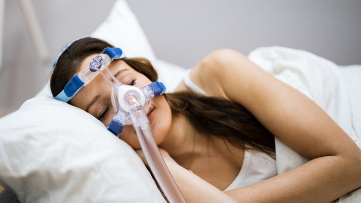 une femme portant un masque à oxygène pour l'apnée du sommeil