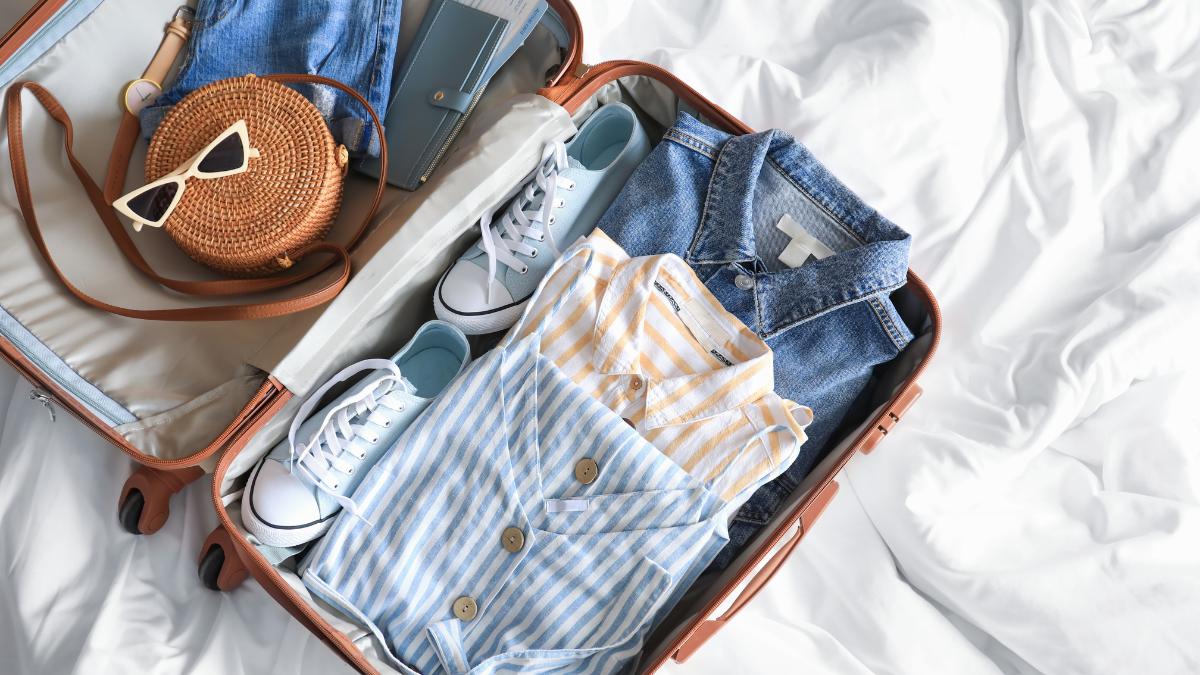 une valise avec des chemises et des chaussures dedans.