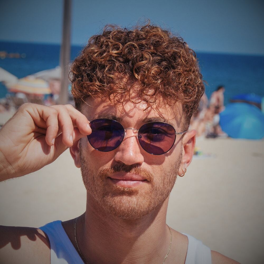 Lucas porte les Ushuaia lunettes de soleil polarisées à la plage devant l'océan