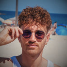 Lucas porte les Ushuaia lunettes de soleil polarisées à la plage devant l'océan