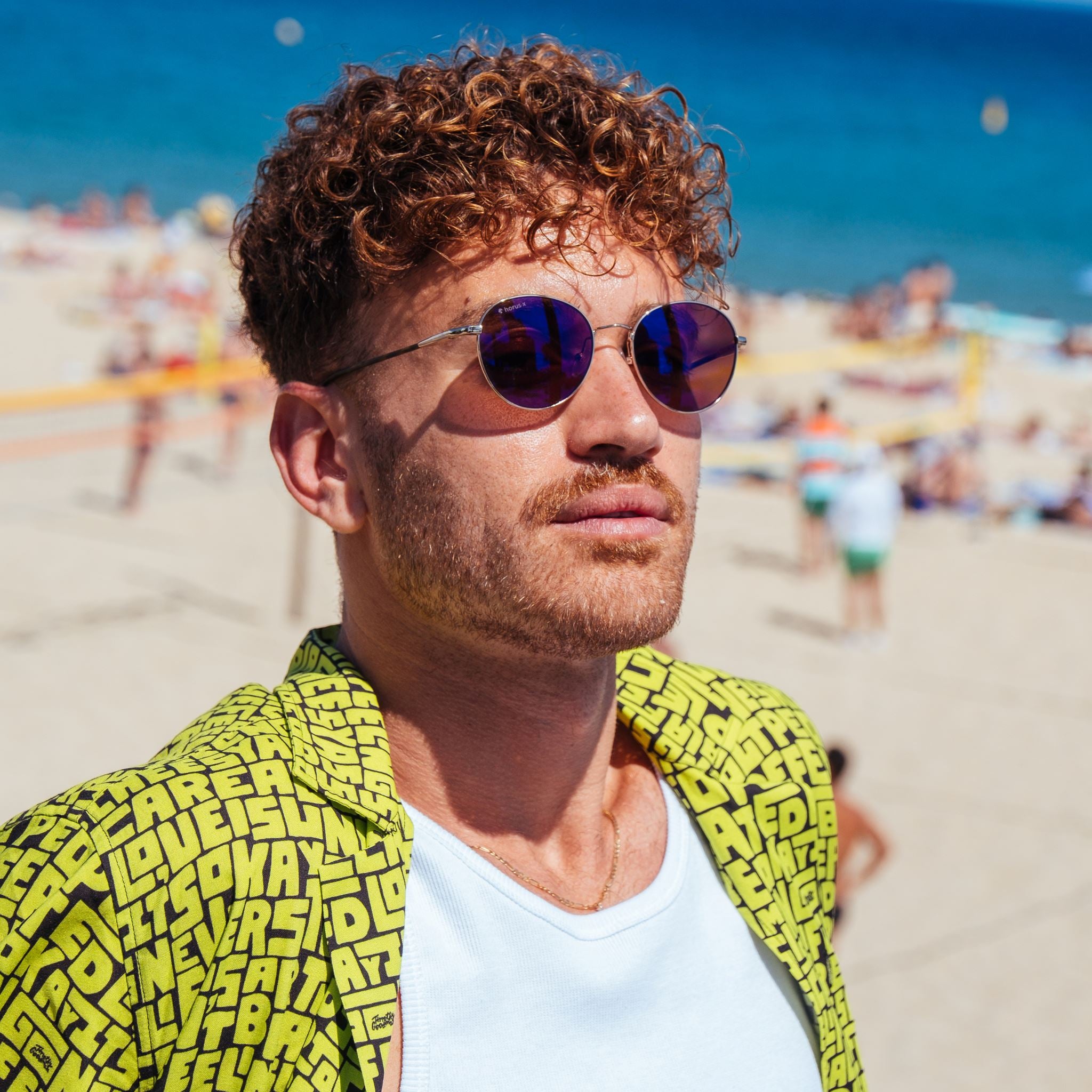 Lucas porte nos lunettes de soleil anti lumière bleue Ushuaia à la plage au soleil devant la mer